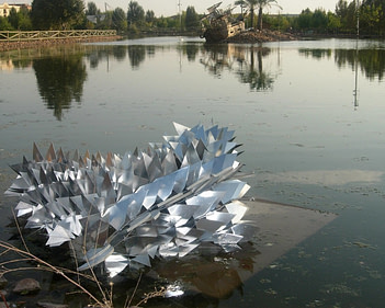 Escamas mecánicas, escultura articulada expuesta sobre un lago en extremadura, España